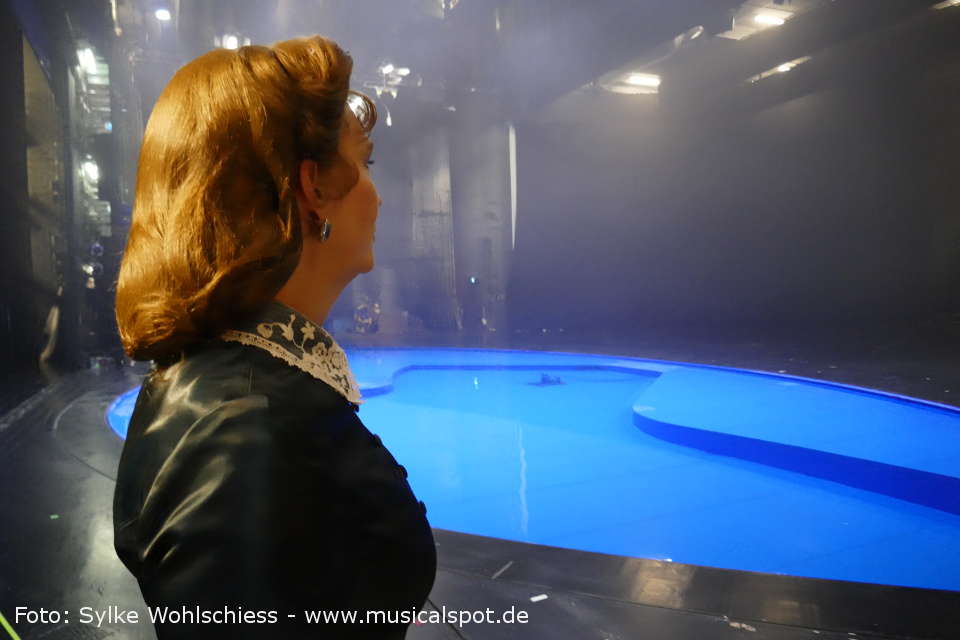 Backstage: Suzan Zeichner zeigt uns den Bühnensee, der in der letzten Szene zum Starnberger See (damals: Würmsee) wird. Dort kam König Ludwig II. am 13. Juni 1886 unter bis heute ungeklärten Umständen zu Tode. suzan zeichner backstage 01