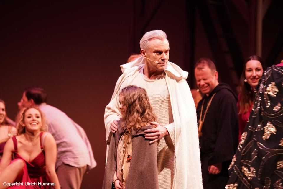 Johanna verblüfft alle mit ihrem Wissen und beweist auch, dass sie nicht nur auswendig Gelerntes wiedergibt, sondern auch die Fähigkeit hat, eigenständig zu denken: 'Eva aß aus Liebe zum Wissen von dem Apfel, während Adam nur aß, weil Eva ihn fragte, ob er ein Stück haben will'. Einen Moment herrscht atemlose Stille - bis Bischof Fulgentius lachend Johannas Aufnahme an der Scola zustimmt. Bleibt die Frage zu klären, wo Johanna wohnen soll. paepstin musical stuttgart 031